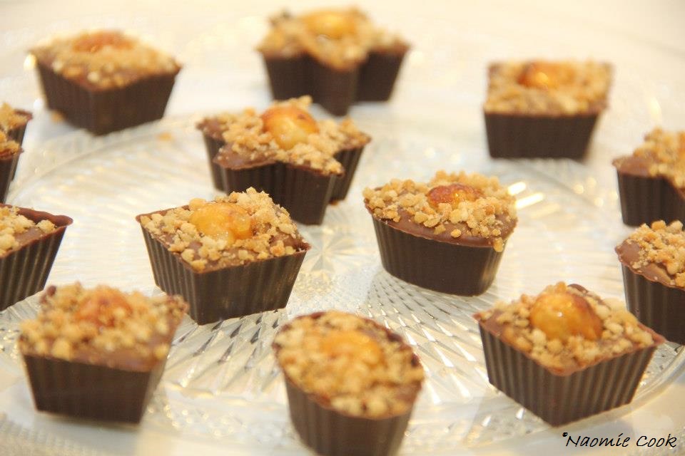 coques en chocolat pralinées surmontées d'une noisette grillée caramélisée et saupoudrées de pralin